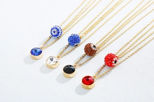 Detail of four gold necklaces with crystal ball and colored round gemstone pendants