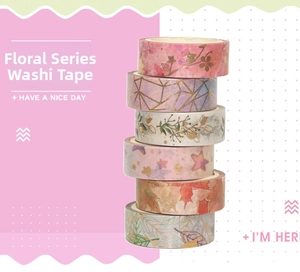 Detail of 6 floral and geometric washi tapes stacked against a pink pattern background