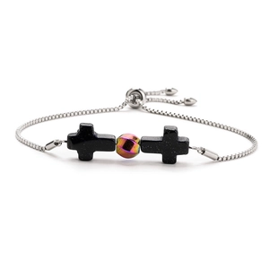 Detailed shot of adjustable stainless steel bracelet featuring black cross and iridescent bead