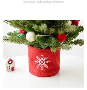 Mini Christmas tree with red ball ornaments and snowflake felt base on a table