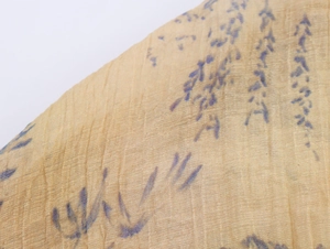 Detailed close-up of light yellow fabric texture with dark blue abstract print patterns