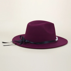 Detail view of burgundy felt wool hat with elegant black ribbon bow and pearl accents