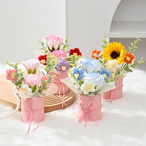 Macro shot of artificial floral gift boxes with pink bows and colorful soap flowers