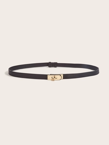 Detail of slim black leather waist belt with gold twist lock on light background