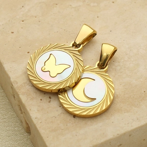 Détail de pendentifs dorés papillon et lune avec incrustation de nacre blanche