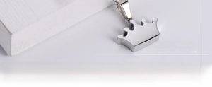 Macro view of mirror-polished silver crown pendant with sleek minimalist metal chain