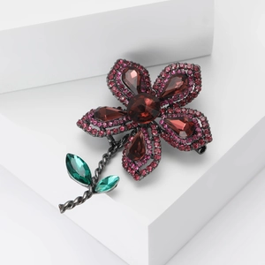 Broche fleur française élégante avec pierres rouge foncé et feuilles vertes sur blanc