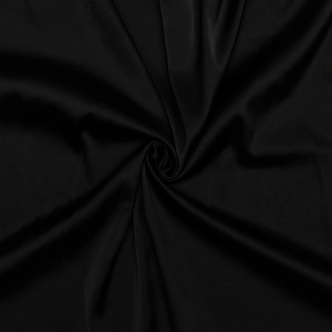 Gros plan du tissu satiné noir lisse montrant une texture soyeuse et des plis élégants