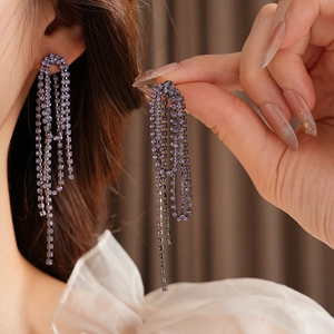 Detailed view of luxury purple crystal fringe earrings with long sparkling tassel strands
