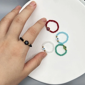 Set of five beaded elastic evil eye rings in black, red, blue, and green crystals