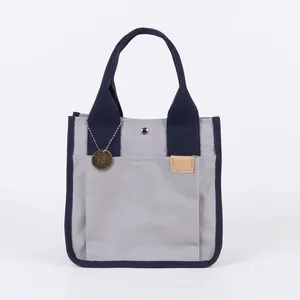 Borsa tote in tela grigia e blu navy con targhetta in metallo vintage e bottone a scatto