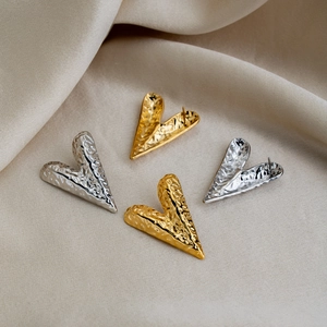 Fashion heart studs with hammered texture in 18K gold and silver plating on silk background