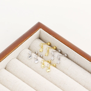 Macro view of gold and silver S925 heart and star screw back studs with clear zircons
