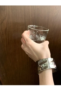 Makroaufnahme des breiten silbernen Metallarmbands mit unregelmäßig gehämmerter Textur