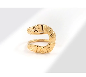 Macro detail of gold U-shaped wrinkled ring with irregular textured lava surface