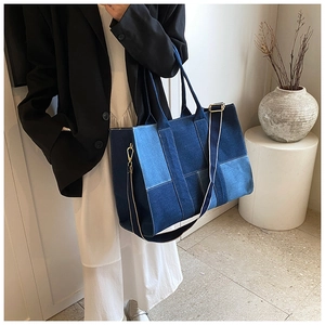 Detail of blue denim patchwork tote bag with adjustable shoulder strap and gold hardware