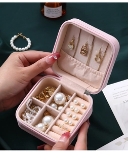 Pink portable travel jewelry box detail with ring slots and necklace hooks inside