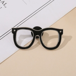 Detailed view of creative black glasses enamel pin with silver trim and secure back buckle