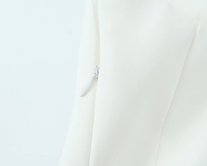 Macro view of white fabric texture and invisible zipper detail on the tube top