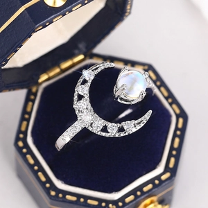 Close-up of moon ring with moonstone and pave crystals in a premium blue velvet box
