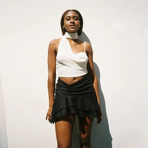 Women's summer two-piece set featuring a white halter crop top and black ruffled mini skirt