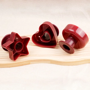 Close-up of heart, star, and round red donut molds on a wooden board for baking