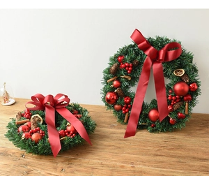 Detail of Christmas wreath featuring red bows, berries, pine cones, and dried orange slices
