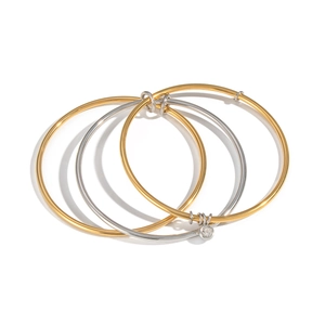 Minimalist multi-layered gold and silver bangle set with sparkling zircon pendant