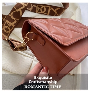 Detail of reddish-brown quilted crossbody bag with wide monogram jacquard strap