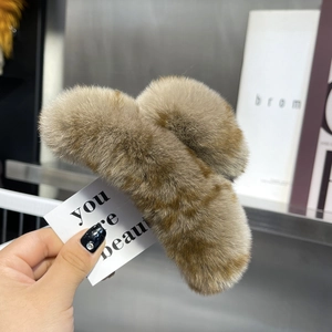Detail of plush faux fur hair claw clip in brown stripes with fluffy texture
