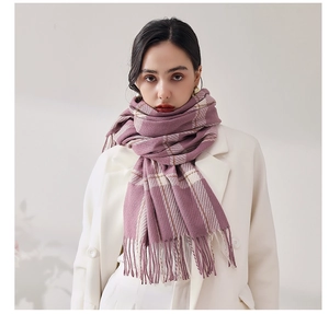 Détail d'une écharpe à carreaux roses avec des franges sur un manteau blanc d'hiver