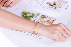 Nahaufnahme eines goldenen Gliederketten-Armbands am Handgelenk in elegantem Lifestyle-Stil
