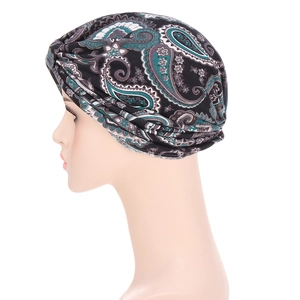 Ethnic paisley print headwrap cap in black and green colors on a white mannequin