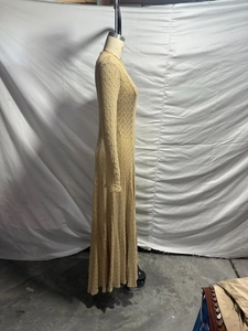 Side view detail of beige knit maxi dress showing intricate hollow-out mesh texture