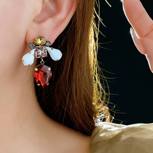 Close-up of vintage gold bee earrings with multi-colored crystals on a model