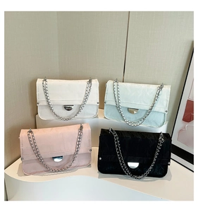 Multiple stylish chain shoulder bags in black, white, pink, and green on display