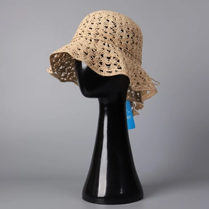 Détail du motif ajouré crocheté à la main et bord ondulé du chapeau en raphia