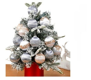Detailed view of silver and gold textured Christmas ball ornaments on a snowy tree