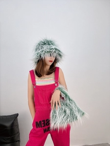 Detail of green faux sheepskin plush hat and matching handbag with pink overalls