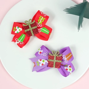 Détail de barrettes de Noël rouges et violettes avec nœuds et petits cadeaux brillants