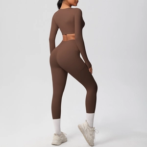 Detail view of the side pocket on high-waisted dark brown yoga leggings and cropped top