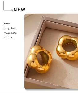 Macro view of polished 18k gold plated stainless steel floral geometric ring on a tray