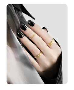 Detailed view of textured S925 sterling silver rings in gold and silver on a model hand