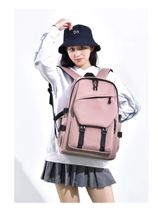 Detail of light pink school backpack with buckles and pockets on a studio model