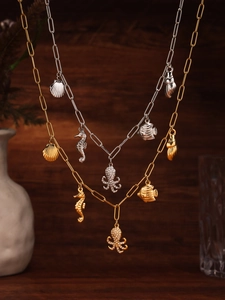 Detailed close-up of gold and silver ocean themed necklaces with sea creature charms
