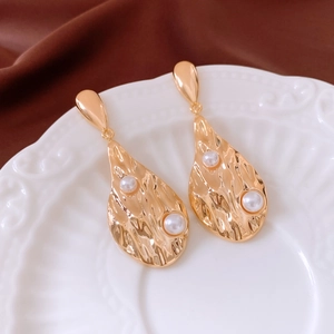 Vue macro de boucles d'oreilles perles plaquées or 18 carats sur un plat vintage