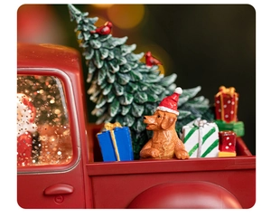 Vue macro d'un camion rouge vintage avec sapin de Noël, golden retriever et boîtes cadeaux