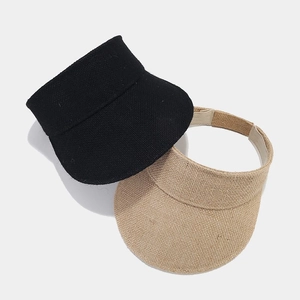 Vista superior de viseras de paja tejidas en negro y beige con cierre de velcro