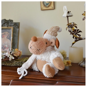 Detail of plush reindeer doll with knitted hat and scarf on vintage wooden surface