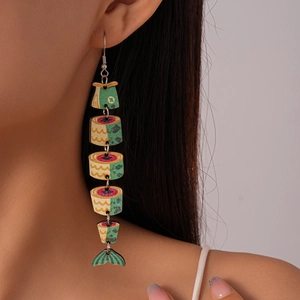 Close-up of long wooden fish earrings with vibrant colorful prints on a female model